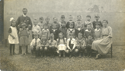 858117 Groepsportret met leerlingen, een onderwijzer en een onderwijzeres van vermoedelijk de Openbare Lagere School ...